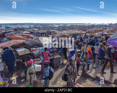 MBour, Senegal- 25 de abril de 2019: hombres y mujeres senegalesas no identificados en el mercado de pescado en el puerto de la ciudad, cerca de Dakar. Hay puestos de venta y Foto de stock
