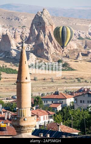 Cappadocia, Turquía: Globo aerostático flotando al amanecer y vista del valle alrededor de Cavusin, ciudad de la región histórica de Anatolia Central Foto de stock