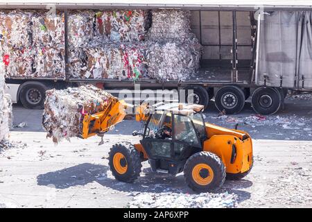Los papeles de desecho apilados se cargan en el camión para su reciclaje Foto de stock