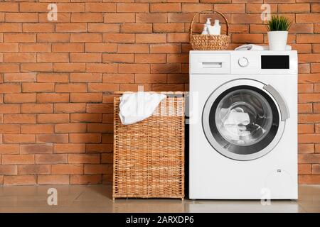 Lavandería cesta de acero inoxidable con ruedas con paños sucios cerca de  la lavadora en la sala de lavandería Fotografía de stock - Alamy