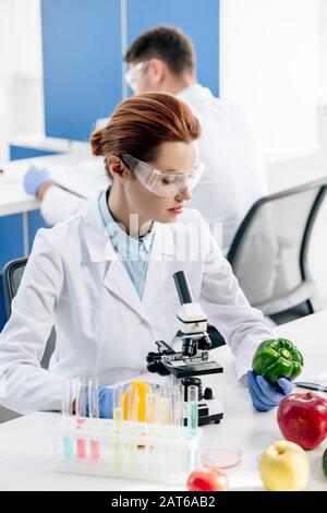 nutricionista molecular sosteniendo y mirando el pimiento en el laboratorio Foto de stock