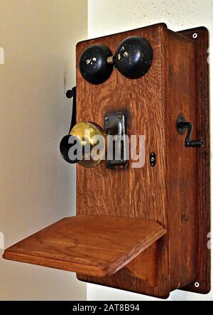 Un viejo teléfono de pared de madera. Foto de stock