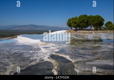 Aguas termales ricas en minerales que fluyen por terrazas travertinas en Pamukkale, Turquía