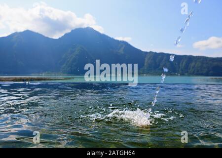 Balneario natural de aguas termales junto al volcán Batur. Agua caliente que fluye a la piscina de borde infinito con un hermoso lago y vistas de la montaña Abang. Destino turístico popular