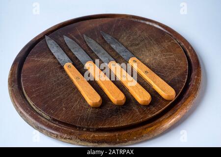 Juego de cuchillos de cocina y tabla de picar sobre un fondo marrón  Fotografía de stock - Alamy