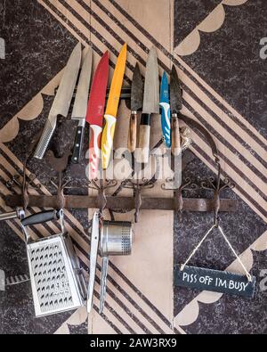 Variedad de utensilios de cocina en un colgador contra la pared de la cocina  Fotografía de stock - Alamy