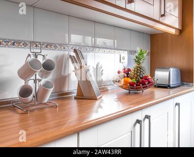 https://l450v.alamy.com/450ves/2aw43rr/detalle-de-frutas-y-utensilios-de-cocina-en-una-elegante-cocina-luminosa-con-armarios-de-madera-espacioso-y-moderno-interior-de-electrodomesticos-totalmente-equipado-con-escritorio-de-madera-2aw43rr.jpg