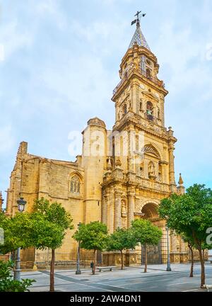 La fachada de la iglesia de San Miguel con ricas decoraciones de piedra caliza tallada, alto campanario con techo de mosaico cónico, Jerez, España