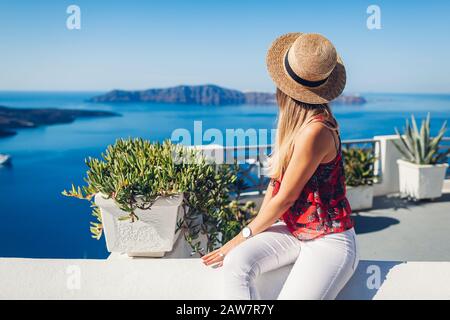 Mujer viajera mirando el paisaje de Caldera desde Thera, isla de Santorini, Grecia. Turismo, viajes, vacaciones Foto de stock