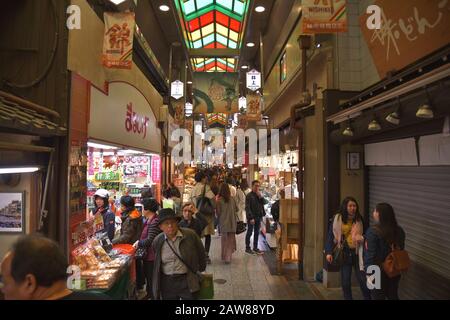 Clientes en el mercado iluminado de Nishiki Foto de stock