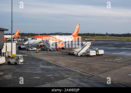 EasyJet Aircraft en stand frente a la terminal de construcción de delantal en el aeropuerto internacional de Belfast, Aldergrove Foto de stock