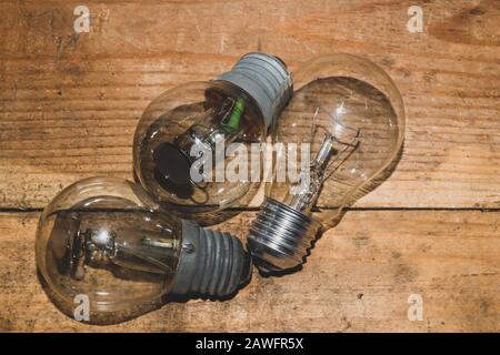 Bombilla sobre fondo de madera. Lámpara vieja en la mesa. Foto de stock