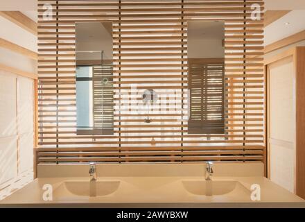 Tocador doble con lavabo y espejo en un moderno y lujoso cuarto de baño interior Foto de stock