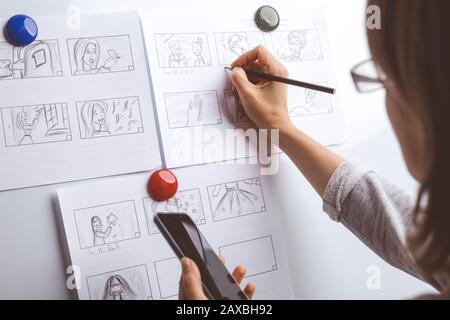 La mano de la mujer dibuja un guión gráfico para una película o una caricatura.