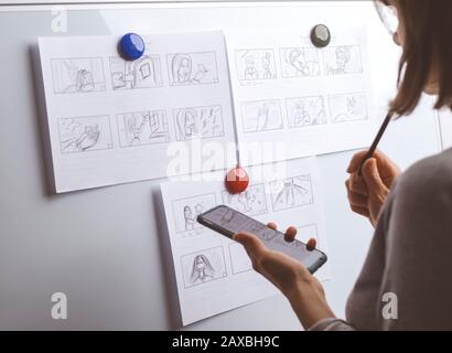 La mano de la mujer dibuja un guión gráfico para una película o una caricatura.