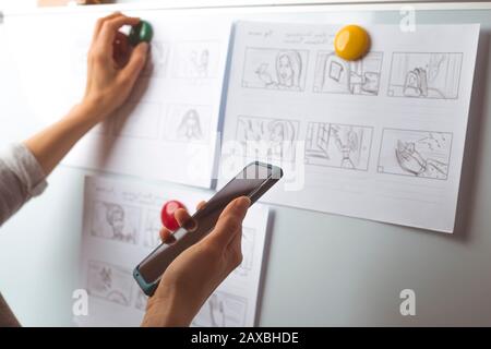 La mano de la mujer dibuja un guión gráfico para una película o una caricatura.