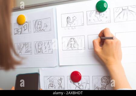 La mano de la mujer dibuja un guión gráfico para una película o una caricatura.