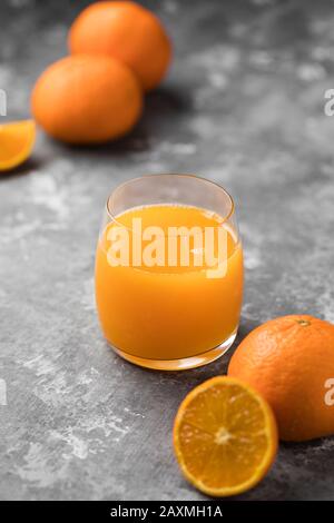 Un zumo de naranja recién exprimido en un vaso transparente Foto de stock