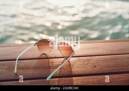 Gafas de sol en el muelle al atardecer. Horizontal Foto de stock