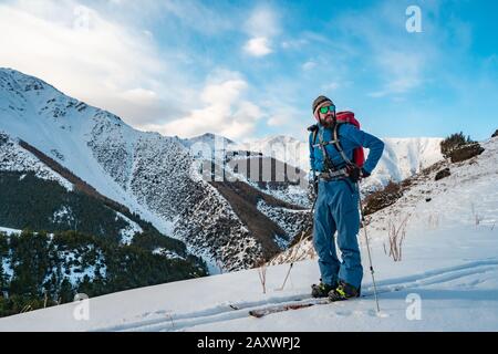Un hombre se dedica a hacer excursiones de esquí en el splitboarding. Amanecer en las montañas. Kirguistán Foto de stock