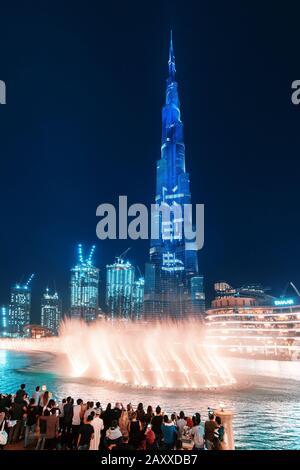 28 de noviembre de 2019, EAU, Dubai: Vista nocturna de la torre iluminada de Burj Khalifa y un estanque con una fuente de baile. Espectáculo popular y majestuoso en D. Foto de stock