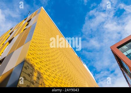 Colores y formas contrastantes en la construcción de fachadas contra el cielo en Manchester, Reino Unido Foto de stock