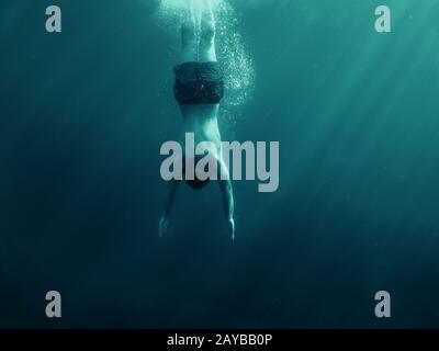 Hombre saltando al agua. Fotografía submarina. Vacaciones, deportes y estilo de vida activo. Foto de stock