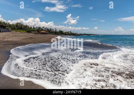 Vista De Pantai Babadan (Playa Babadan), Canggu, Bali, Indonesia. Arena negra volcánica, olas del océano, palmeras.