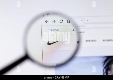 Ordenado tener reservorio Logotipo de la empresa Nike en un sitio web con una evolución borrosa del  mercado de valores en segundo plano, visto en una pantalla de ordenador a  través de una lupa Fotografía