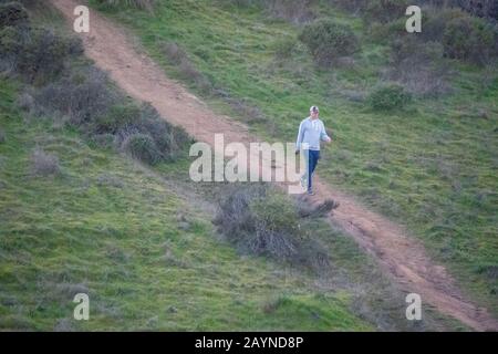 Un hombre camina cuesta abajo en Sorich Ranch Park en San Anselmo, CA. Foto de stock