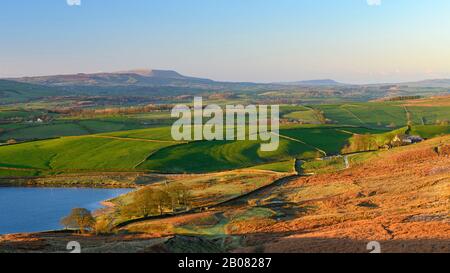 Vistas panorámicas de la mañana rural (Embsay Reservoir, fells o páramos iluminados por el sol, campos agrícolas en el valle, altos altiplanos y Pendle Hill) - North Yorkshire, Inglaterra, Reino Unido.