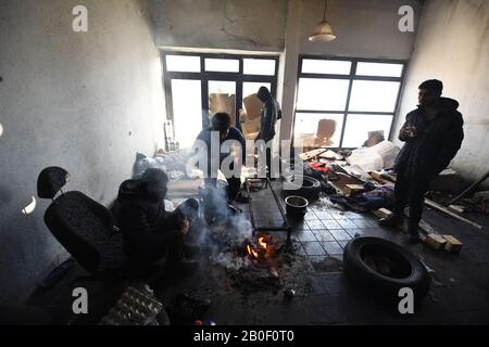 Los refugiados pakistaníes se mantienen calientes en un edificio abandonado en el campamento de Bira en Bihac.Bihac, en el noroeste de Bosnia y Herzegovina, es uno de los epicentros de los refugiados migratorios a lo largo de la ruta de los Balcanes, con tantos refugiados procedentes de diversos países, la tensión está aumentando entre las distintas nacionalidades. La población Bosnia es sorprendentemente tolerante a pesar de que se abusa de su pintoresca ciudad. Foto de stock