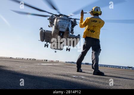 La aviación de la Marina de los EE.UU Boatswain's Mate (manejo) marinero Noel Kulloda señales al piloto de un tipo CH-53E Super Stallion asignado al escuadrón de helicópteros pesados de Marina (HMH) 361, aviones marinos Grupo 16, 3º Marine de alas de avión, durante las calificaciones de aterrizaje de cubierta a bordo del USS Essex (LHD-2) como parte del ejercicio Alba Blitz en el océano Pacífico frente a las costas de California el 21 de octubre de 2017. Amanecer Blitz es un escenario-driven ejercicio anfibio realizado entre Expeditionary Strike Group 3 y 1ª Brigada Expedicionaria de la Marina, probando su capacidad para llevar a cabo operaciones anfibias en respuesta a las crisis mundiales y a proy.