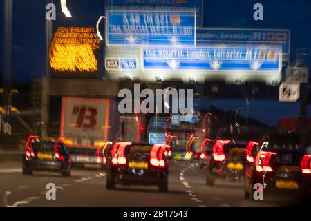 Tráfico de autopista y señales por la noche, en el cruce 23A en la M1, Castillo Donnington, Nottingham, Nottinghamshire, Inglaterra