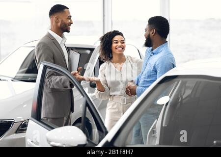 El Manager Habla Con Los Compradores Que Venden Automóviles En La Tienda Del Concesionario