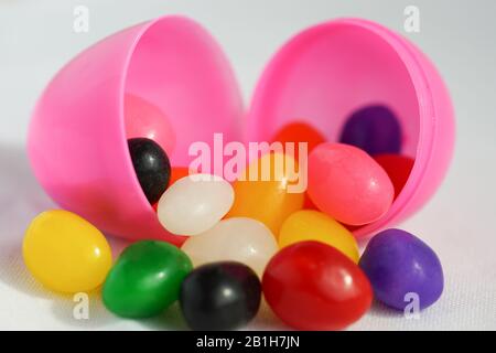 Los coloridos granos de gelatina se derraman de los huevos de Pascua de plástico