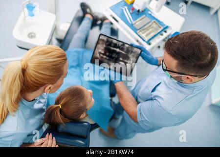 Dentista examinando los dientes de un paciente en dentista office.dentista explicando la imagen de rayos X a paciente.Dientes concepto de salud.Personas,estomatología y salud c Foto de stock