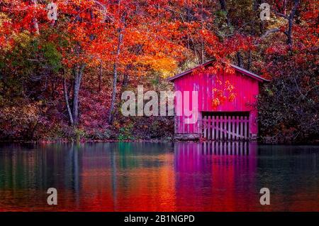 Las hojas de otoño y un boathouse rojo ofrecen un toque de color en DeSoto Falls, 4 de noviembre de 2017 en Mentone, Alabama. Foto de stock