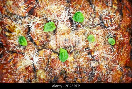 Concepto de comida italiana. Berenjena horneada con queso sobre fondo blanco. Parmigiana melanzane. Vista superior. Foto de stock