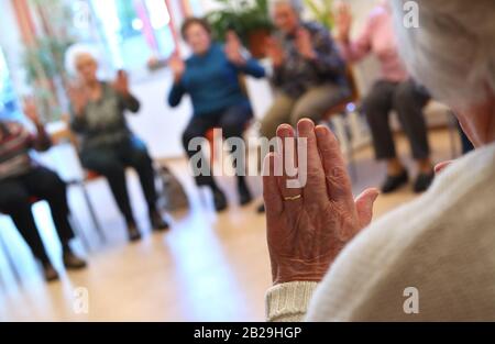 Altusried, Alemania. 21 de febrero de 2020. Los ancianos se sientan juntos en la comunidad residencial de demencia durante una sesión guiada de gimnasia. Vivir de manera auto-determinada a pesar de la enfermedad es el objetivo de la comunidad (dpa-KORR: "Aquí mi madre puede ser un ser humano" - la vida cotidiana en un piso compartido de demencia"). Crédito: Karl-Josef Hildenbrand/dpa - ATENCIÓN: Sólo para uso editorial en relación con los informes actuales y sólo con la mención completa del crédito/dpa/Alamy Live News