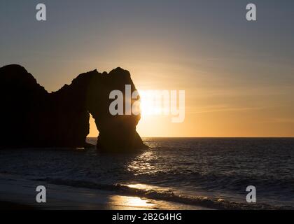 Salida del sol sobre el mar, puerta Durdle, Costa Jurásica, Dorset, Inglaterra, Reino Unido