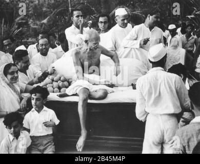 Mahatma Gandhi distribuyendo mangos a los niños después de la oración en Juhu Beach, Mumbai, Maharashtra, India, Asia, mayo de 1944 - VERSIÓN MODELO NO DISPONIBLE