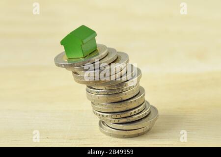 Casa en pila de monedas - Concepto de inversión inmobiliaria y mercado inmobiliario