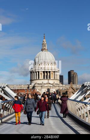 Turismo en el Reino Unido; turistas cruzando el Puente del Milenio frente a la Catedral de San Pablo en un día soleado en marzo, el centro de la ciudad de Londres, Londres, Reino Unido