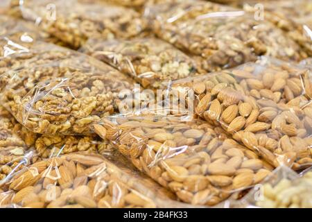 Envasado a partir de una bolsa transparente con almendras y nueces. Primer plano.