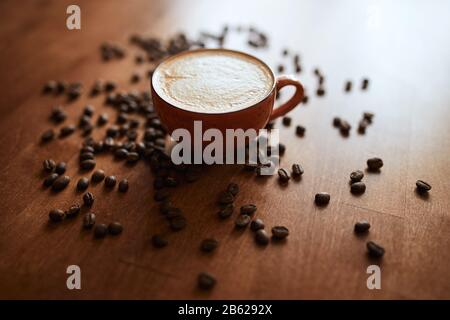 Taza de café con leche en forma de corazón, granos de café en la mesa  Fotografía de stock - Alamy