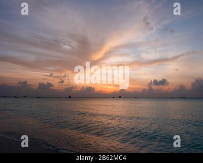 Puesta de sol en Maldivas en la isla tropical Meeru. Puesta de sol en el mar. Paisaje Con Hermosos Colores. Playa Tropical. Concepto De Vacaciones De Verano.