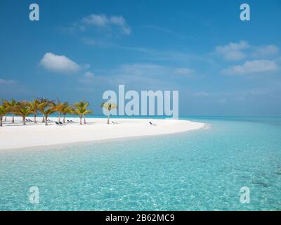 Playa idílica en Maldivas en la isla de Meeru con palmeras, cielo nublado y océano Índico. Foto de stock