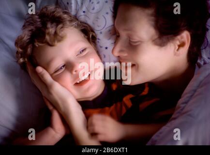 Madre e hijo abrazando en la cama
