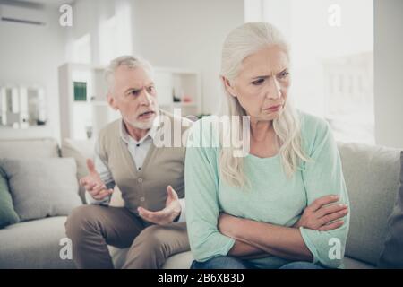 Foto de cerca de la vieja abuela triste y de pelo largo no quiere escuchar a su marido estricto que está enviando reclamaciones Foto de stock